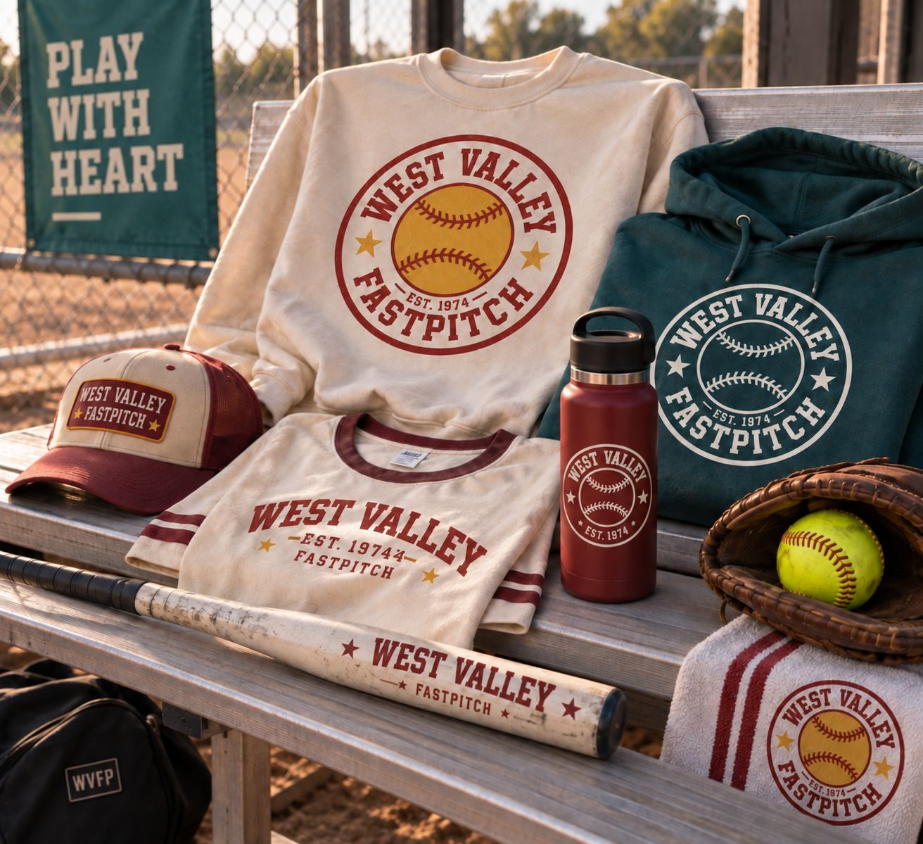 A flat-lay of West Valley Fast Pitch merch: crewneck, tees, cap, hoodie, water bottle, and towel.